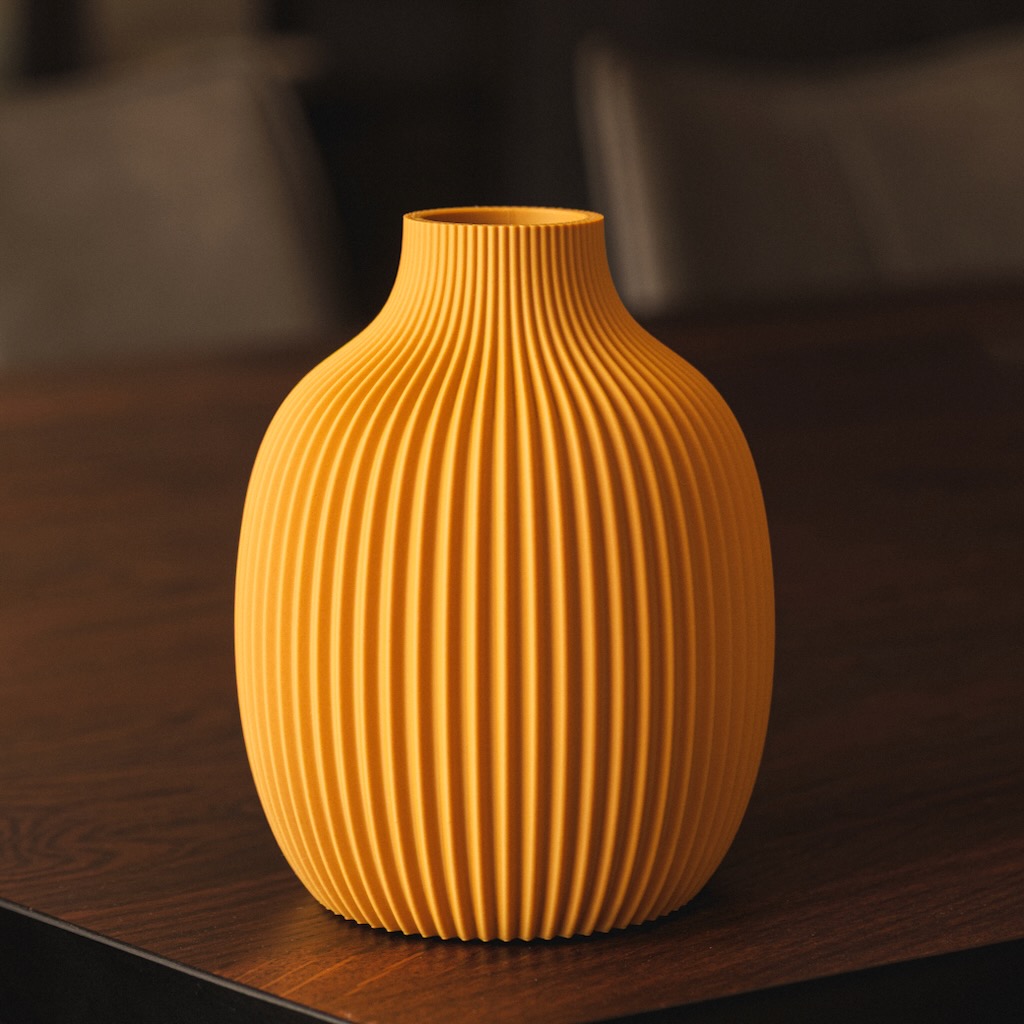 Vaso di design color ocra con superficie a coste verticali, stampato in 3D